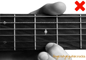 Not fretting the strings as close to the fret wire as possible
